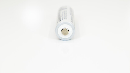 One alkaline battery on a white background with reflection. Energy supply and recycling concept. Copy space. Minimalism. Eliment AA is the most common type of galvanic batteries and accumulators.