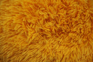 the lint of bright yellow faux fur is close . texture of yellow fabric