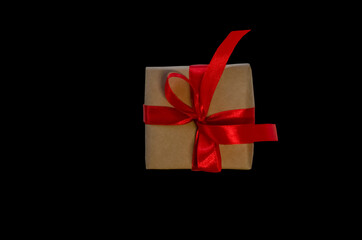 Gift box with red ribbon, copy space isolated on black background. Sales concepts, discount price, black friday, christmas gifts and shopping, greeting card for christmas, valentine's day or new year
