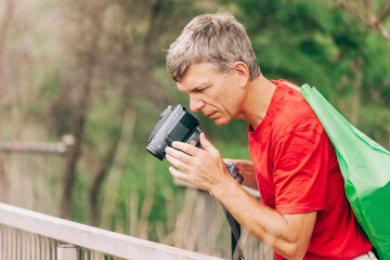 Mature man filming with camcorder