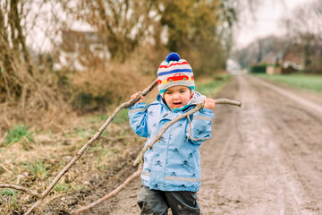 Happy toddler girl playing with sticks