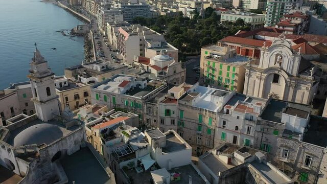 Beautiful panoramic aerial 4K video from flying drone on Molfetta waterfront and the old town from a great height.Port with ships and yachtsand the Molfetta new city at sunrise.Apulia,Italy (Series)