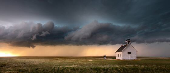 Old abandoned church in the countryside of Colorado under a dramatic sky.