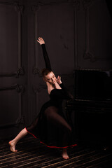 Beautiful female classical ballet dancer on pointe shoes wearing leotard and skirt in studio