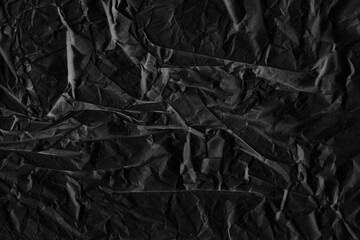 Black vintage and old looking crumpled paper background. Retro cardboard texture. Grunge paper for drawing. Ancient book page. Present wrapping.