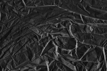 Black vintage and old looking crumpled paper background. Retro cardboard texture. Grunge paper for drawing. Ancient book page. Present wrapping.
