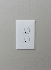 A white American electrical outlet on a stucco wall in southwest America