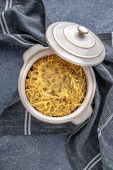 Casserole, risotto, or lasagne with cheese. Natural delicious food. Greek cuisine menu. Still life in a marine style on a blue background.