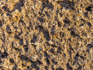 The dark gray stone is lit by the sun at sunset. Use for background.