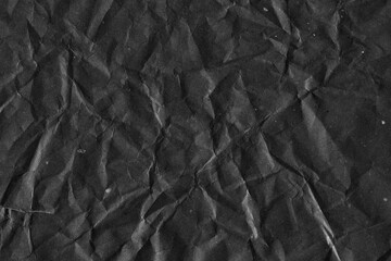 Black vintage and old looking crumpled paper background. Retro cardboard texture. Grunge paper for drawing. Ancient book page. Present wrapping.