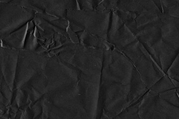 Fototapeta premium Black vintage and old looking crumpled paper background. Retro cardboard texture. Grunge paper for drawing. Ancient book page. Present wrapping.