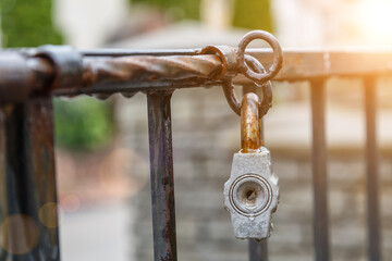 Rusty padlock on the door. Closed old locked gate. Closed lock on the grating fence