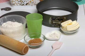 Butter on a kitchen scale. Sugar and flour in containers, collapsible baking dish. Levington cake, stages of preparation.