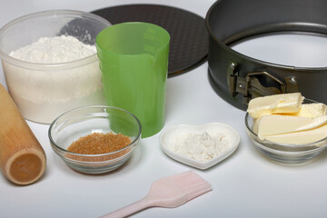 Butter on a kitchen scale. Sugar and flour in containers, collapsible baking dish. Levington cake, stages of preparation.