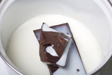 Milk chocolate in a saucepan. Levington cake, stages of preparation.