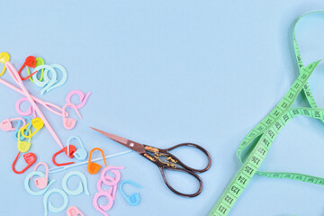 Little things for sewing and knitting are laid out in a mess next to scissors and a centimeter