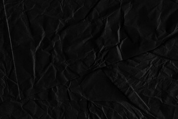 Black vintage and old looking crumpled paper background. Retro cardboard texture. Grunge paper for drawing. Ancient book page. Present wrapping.