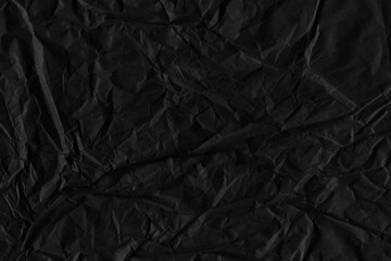 Black vintage and old looking crumpled paper background. Retro cardboard texture. Grunge paper for drawing. Ancient book page. Present wrapping.