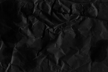 Black vintage and old looking crumpled paper background. Retro cardboard texture. Grunge paper for drawing. Ancient book page. Present wrapping.