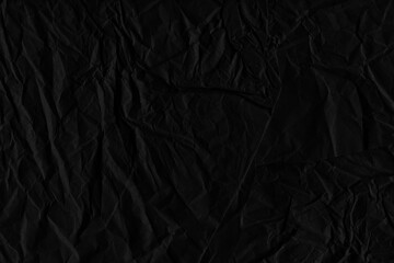 Black vintage and old looking crumpled paper background. Retro cardboard texture. Grunge paper for drawing. Ancient book page. Present wrapping.