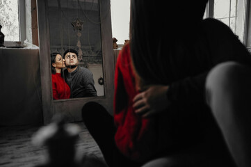 Mirror reflection of a young couple sitting on the floor