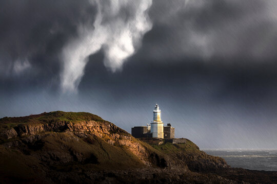 Stormy weather and rain over Mumbles lighthouse on Swansea Bay, South Wales, UK
