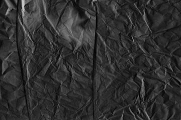 Black vintage and old looking crumpled paper background. Retro cardboard texture. Grunge paper for drawing. Ancient book page. Present wrapping.