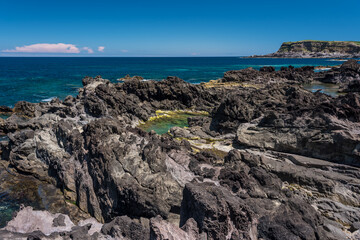 natural pool  in terceria.
view of the rocky seaside in terceira with natural pool to have a bath, seascape in azores, portugal.