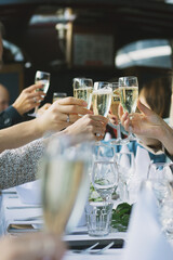 people raising champagne glasses to make a toast at a party table - 384450374