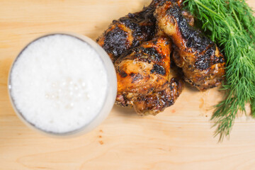 grill chicken, green and beer on a woowen plate.