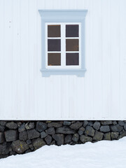 Light blue window on a white wooden house in winter. North Iceland.