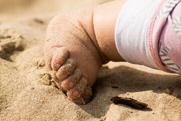 El pie de un bebe sobre la arena de la playa