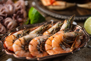 Close-up view of dish with large tiger shrimps with assorted seafood background. Healthy food. Thai cuisine.