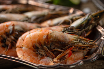 Close-up view of shrimp on the metal dish with other shrimps background. Seafood concept. Gifts of the red sea.