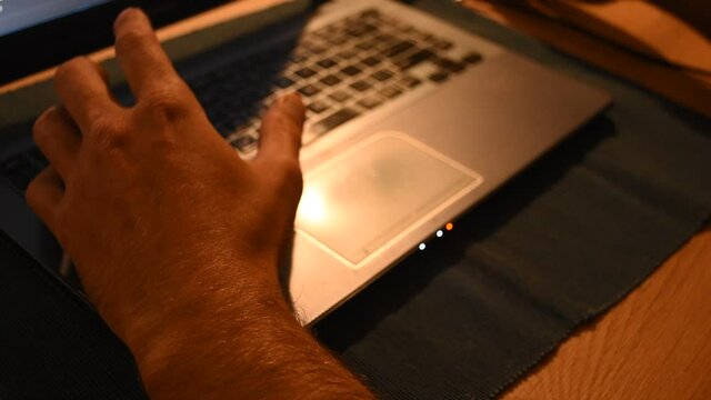 Hombre escribiendo en teclado de ordenador preocupado. Manos escribiendo en notebook, ansiedad, nervios. 