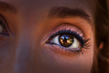 Beautiful brown eye of a woman, in which her photographer is reflected