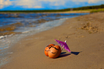 easter funny eggs under umbrella on a beach