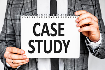 business, technology, internet and networking concept - businessman in gray fashionable business suit holding a white notebook with conference inscription CASE STUDY inscription