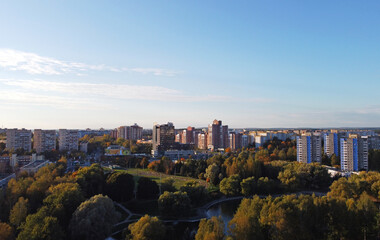 Fototapeta premium Top view of a beautiful autumn park in the city with houses
