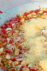 cooking spanish paella with seafood and meats in outdoor area.