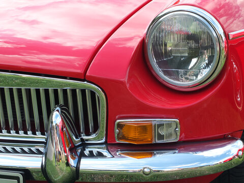 Hebden Bridge, West Yorkshire, England - Augustclose up of the front of a classic red british mgb sports car showing headlamp and chrome bumper at the Annual Hebden Bridge Vintage Weekend Vehicle Show