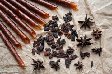 Rolled pastila sticks and star anise dried fruits on beige paper background