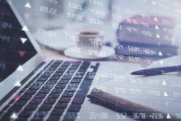 Double exposure of financial chart drawing and desktop with coffee and items on table background. Concept of forex market trading