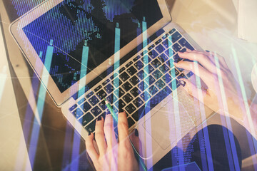 Double exposure of woman hands working on computer and forex chart hologram drawing. Top View. Financial analysis concept.