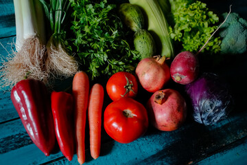 red and green fresh vegetables fruits on blue wood