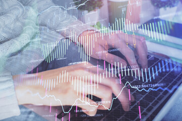 Double exposure of woman hands typing on computer and forex chart hologram drawing. Stock market invest concept.