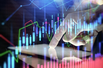 Double exposure of man's hands holding and using a digital device and forex graph drawing. Financial market concept.