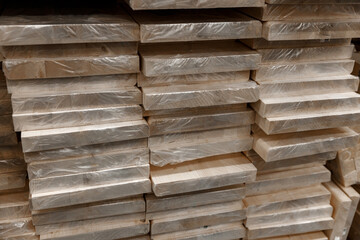 Boards made of pine needles are stacked and sealed with polyethylene. The concept of furniture made of natural wood