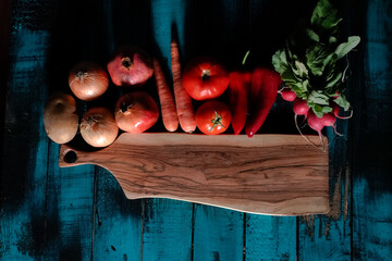 fresh red vegetables and fruits on blue wood