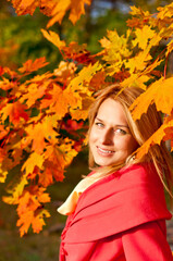 Naklejka na ściany i meble Autumn woman on leafs background